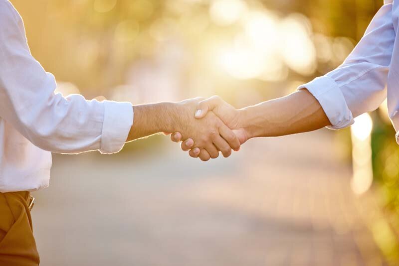 Shaking hands on a video deal to create content for a business owner.